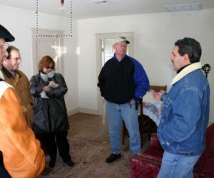 The four-room shack had simple pine floors. When the knotholes fell out, they replaced them with tin can lids.