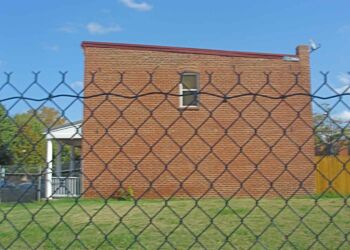 The now empty lot was once occupied by six attached row houses facing the left field wall, each with a small, enclosed backyard