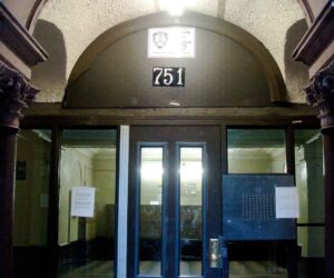 A leaded stain glass window with bats crossed over a heraldic shield dominated the lobby. Mailboxes now obscure it.